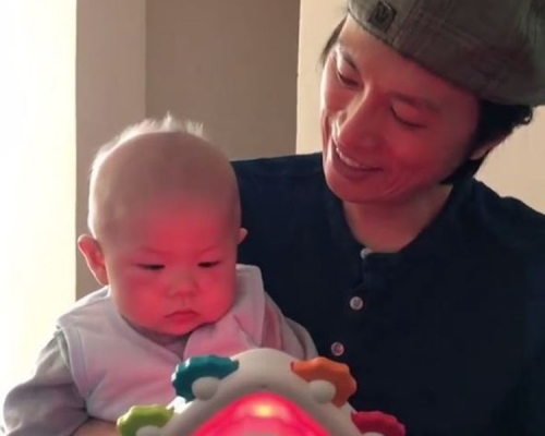子華抱住Jazz，用會發光的玩具吸引他注意。
