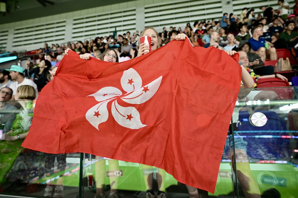 港隊球迷揮舞區旗打氣。