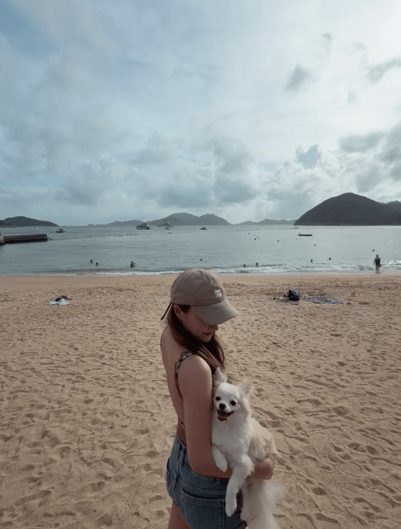 陳瀅單手抱起愛犬漫步沙灘，大露背泳衣剪裁盡現白滑玉背。
