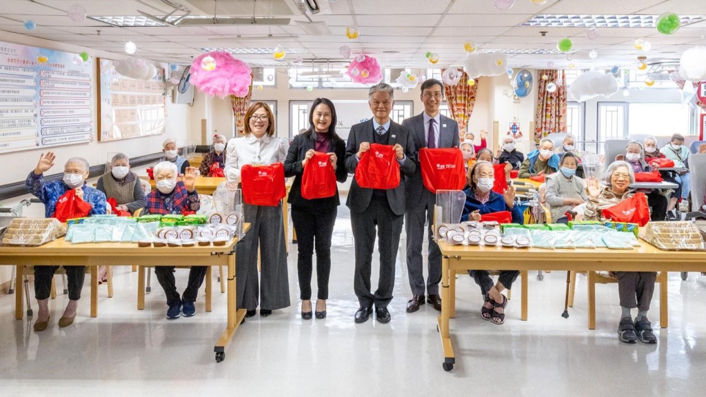 鄭祖瀛（右二）向東華三院方樹泉社會服務大樓內護理安老院的長者派發新年福袋，並為長者的晚餐「加餸」，送上地區名物「魚蛋（魚丸）拼片頭（魚片頭）」，現場洋溢溫暖氣氛。 