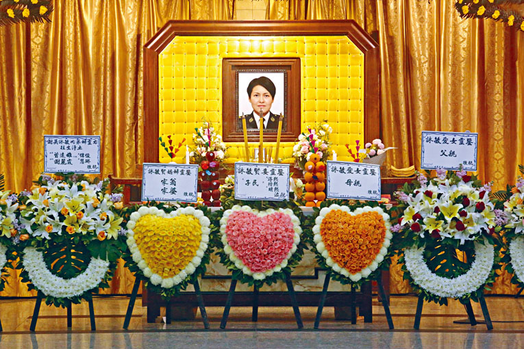 殉職高級關員吳詠敏遺照前,擺放其父母和家人致送花圈。