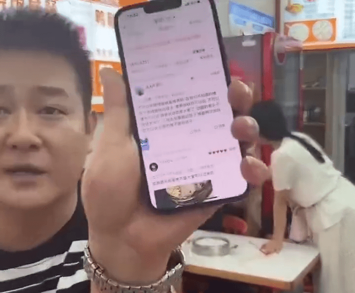 麵店老闆展示顧客的負評。