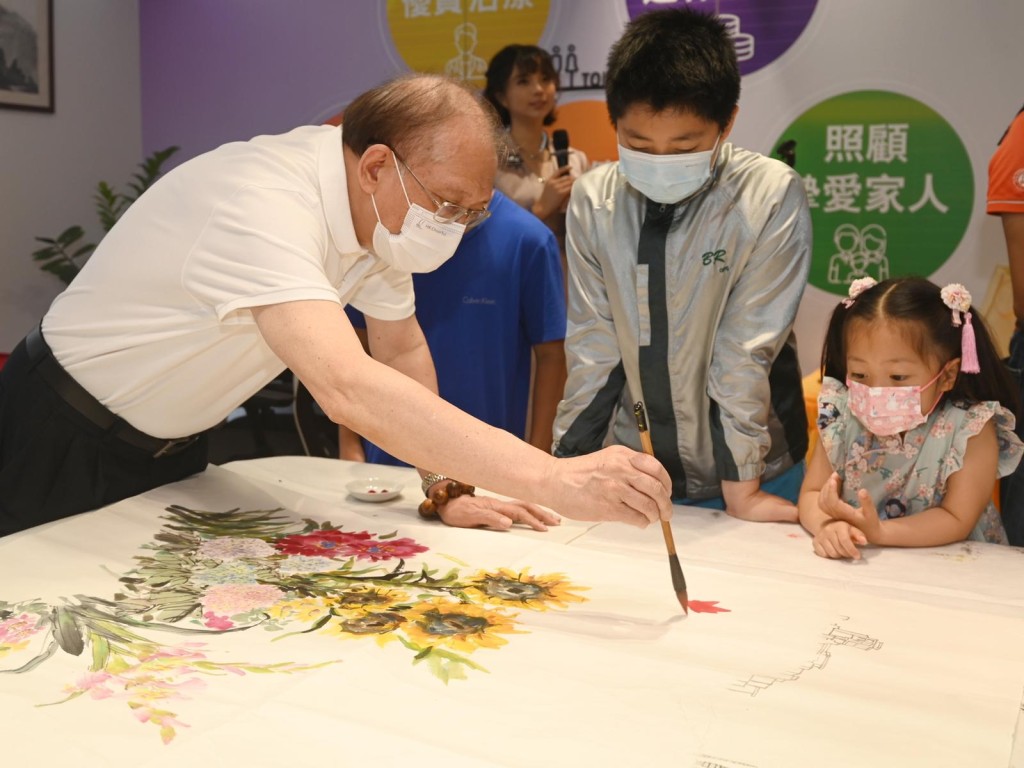 5名书画家带领小朋友一起完成八尺巨型百花图。