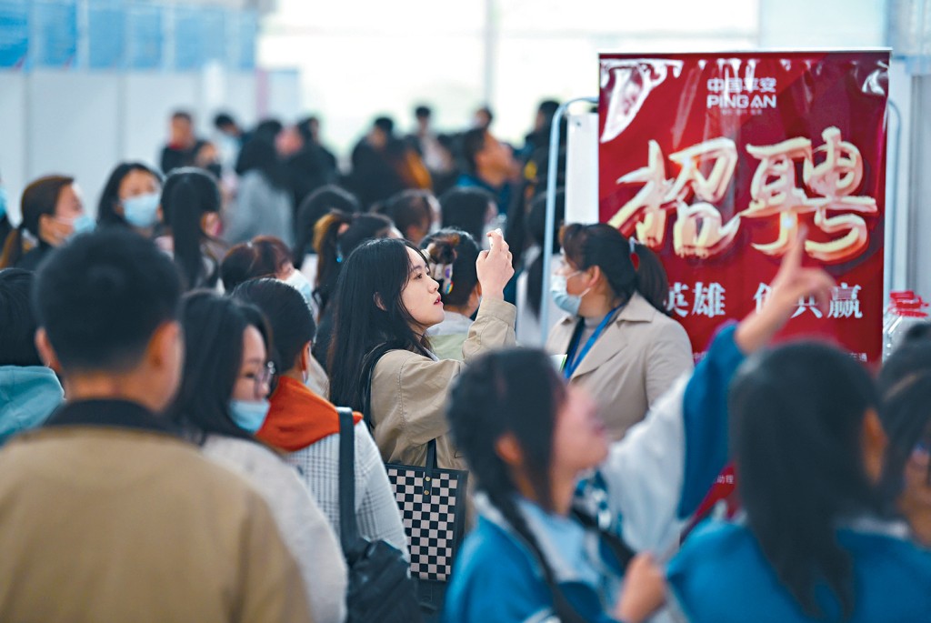 寧夏銀川招聘會上,一女子用手機拍下崗位訊息。