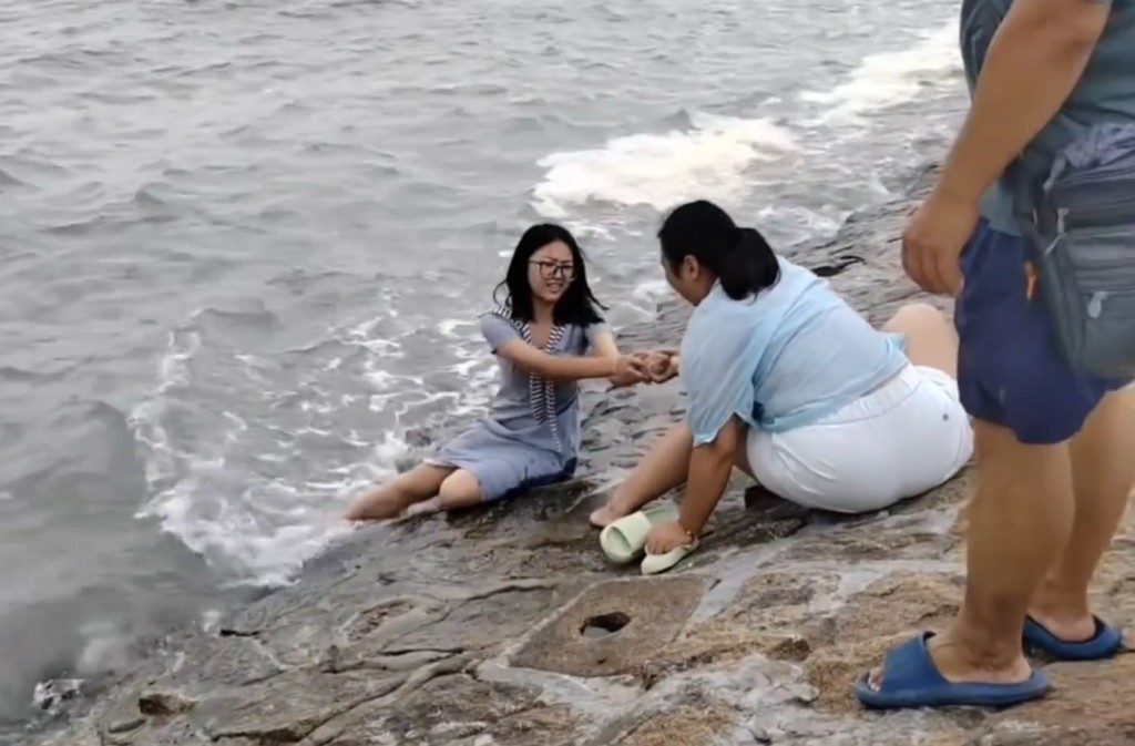 廣西女失控圖落海撈回手機遭母親死命拉著。微博