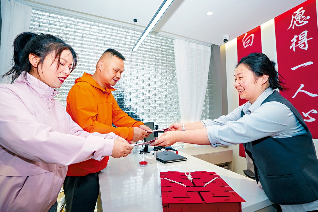 南京市玄武區婚姻登記處工作人員為新人發結婚證。 南京市玄武區婚姻登記處工作人員為新人發結婚證。