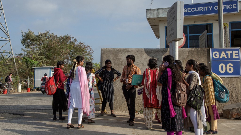 在印度清奈附近的富士康工厂外，求职者与招聘代理交谈。 路透社