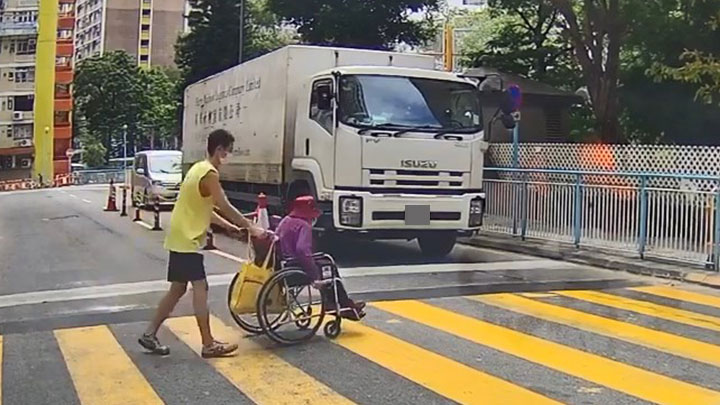 一名穿黃色背心的貨車司機見義勇為推婆婆過馬路。網上片段截圖