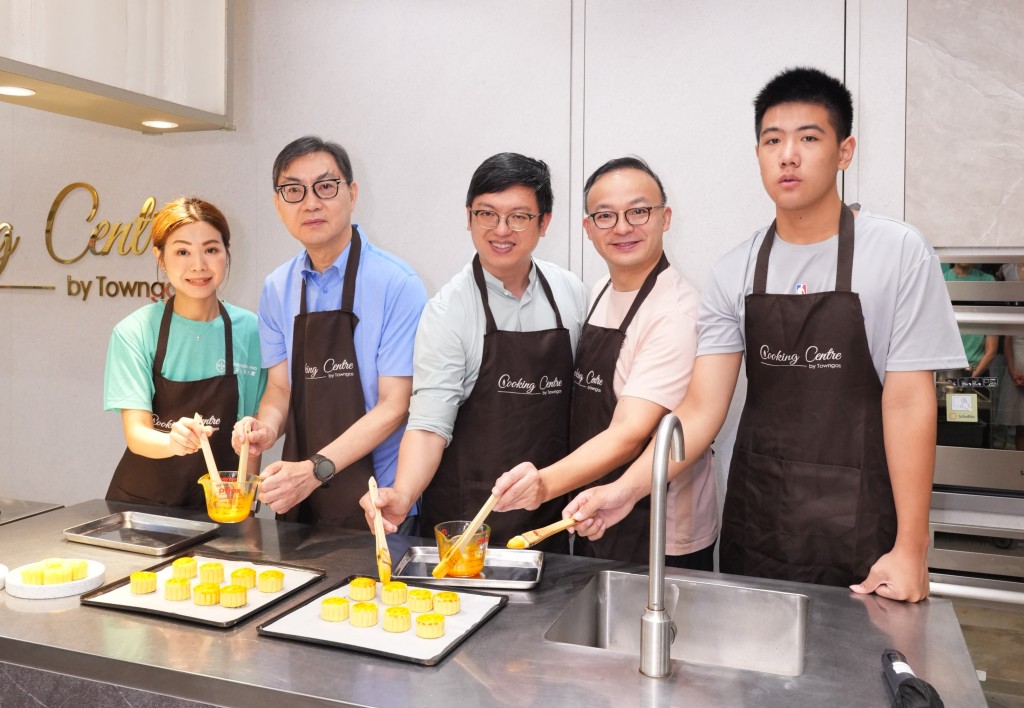 出席恒基「中秋愛心月餅製作送暖活動」 的勞工及福利局副局長何啟明先生(中)， 聯同恒基地產執行董事黃浩明先生(左二) 與參與義工及「共創明『Teen』計劃」 參加者，一同製作愛心奶黃月餅。恒地提供