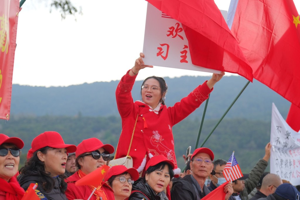 一名女華裔僑民高舉「歡迎習主席」的牌子。彭詩喬攝