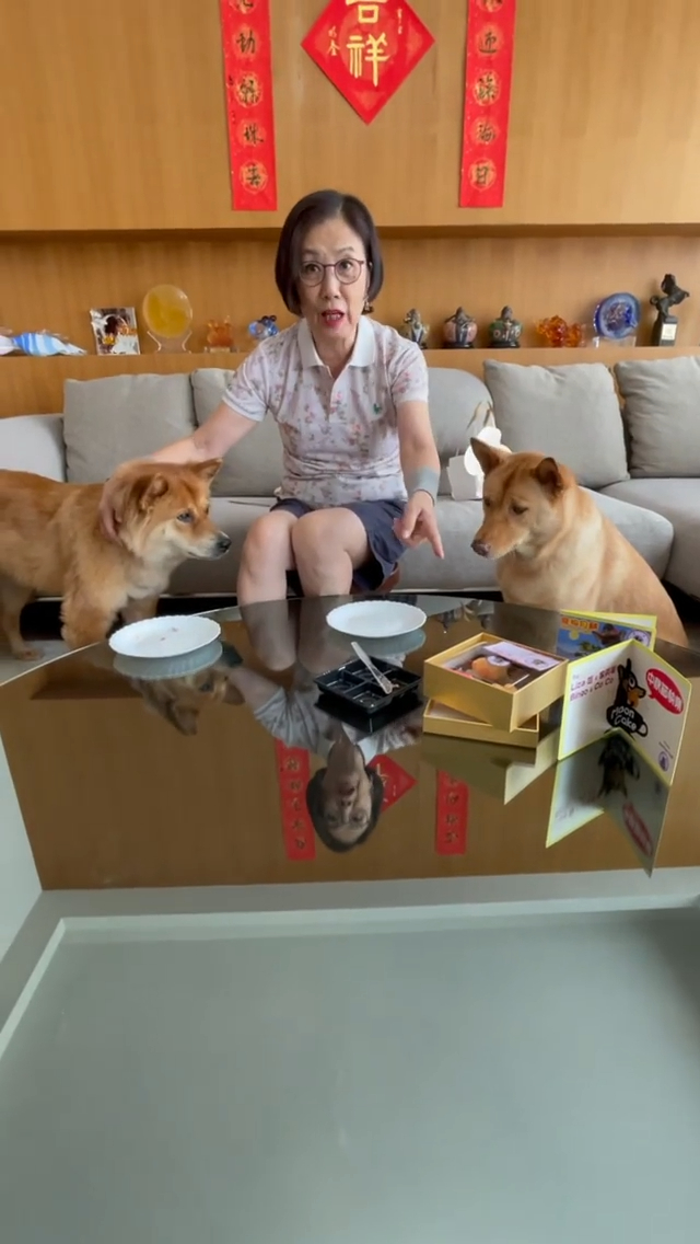 跟兩愛犬對鏡頭向送禮人說多謝。