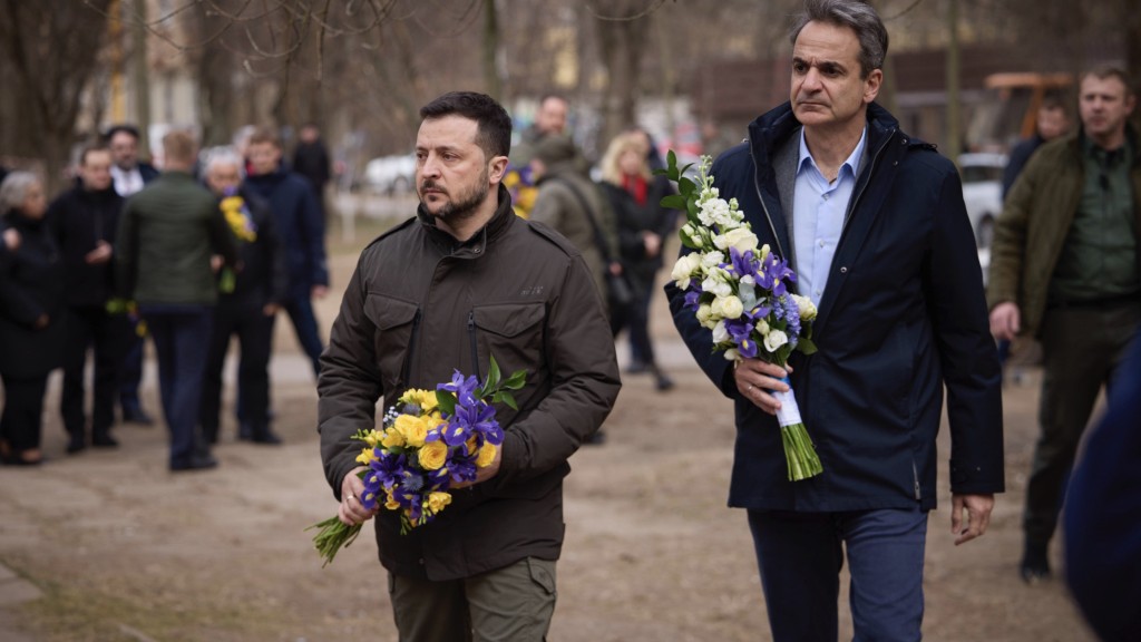 泽连斯基和希腊总理米佐塔基斯（左二）在敖德萨遇袭地点献花悼念。 美联社