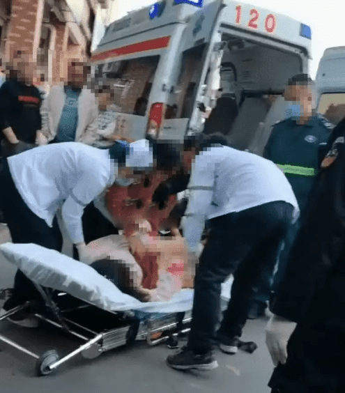 女生被醫護人員和圍觀群眾用擔架抬上了救護車。
