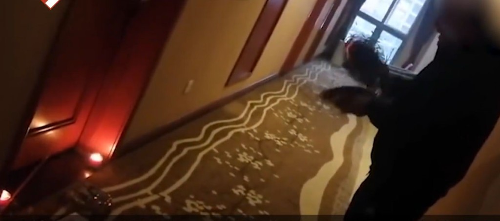 視頻顯示，一名疑似死者親人的男子頭上纏著白布，在酒店的走廊上，手拿鑼鈸打擊。 網圖