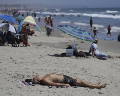 加州氣溫颷升至37至43度高溫市民湧往沙灘消暑。AP