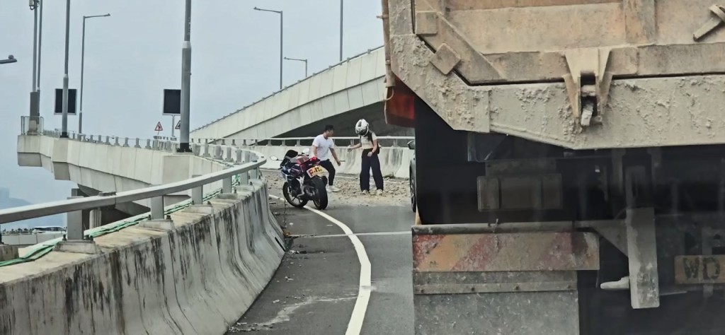九龍灣國際展貿中心對開的觀塘繞道支線上,有大量沙石瓦礫跌於路面。網上片段截圖 九龍灣國際展貿中心對開的觀塘繞道支線上,有大量沙石瓦礫跌於路面。網上片段截圖