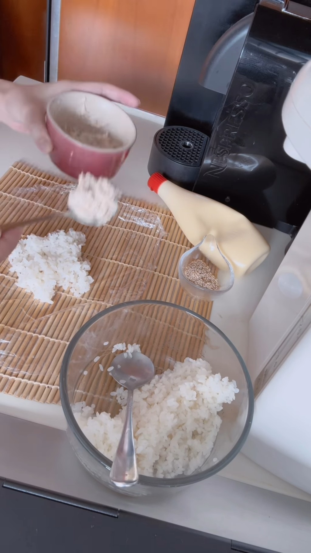 用一张保鲜纸先铺在桌上，然后在保鲜纸上舀上适量的珍珠米饭，把珍珠米饭铺平后加入已捞好的吞拿鱼酱。