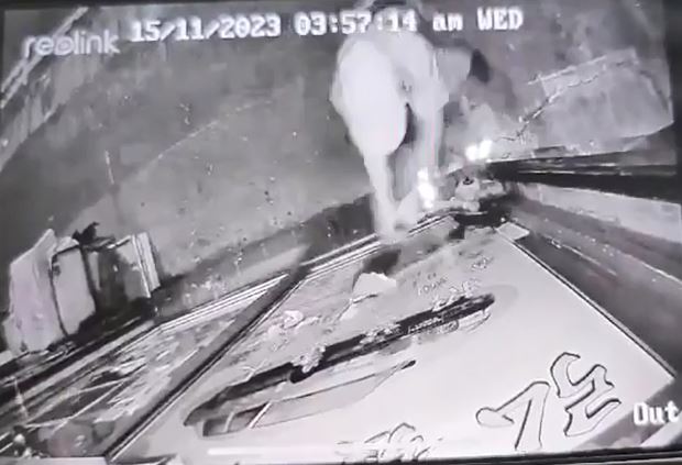 鸭舌帽男子用硬物砸爆地产铺玻璃。闭路电视片段截图