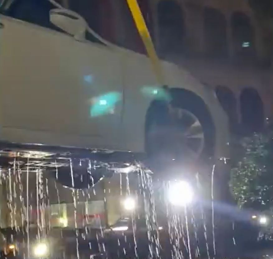 茂名有居民为免爱车被水淹坏，找「吊鸡车」将汽车吊上天台避水。影片截图