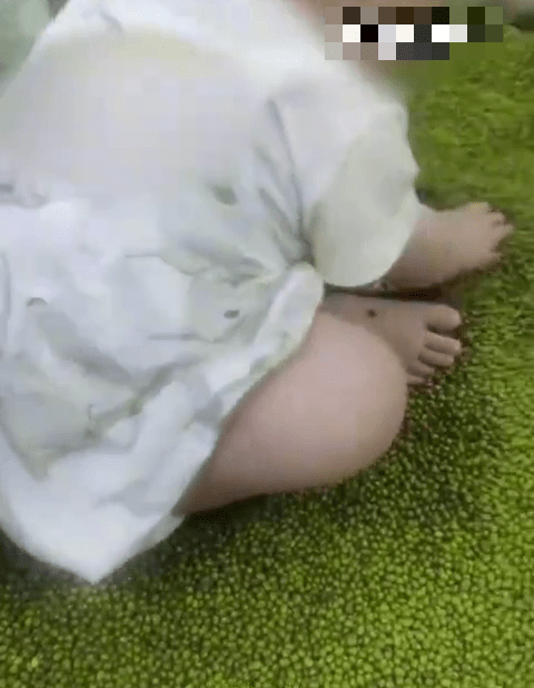 穿尿片的幼嬰在超市綠豆堆中抓著玩。 穿尿片的幼嬰在超市綠豆堆中抓著玩。