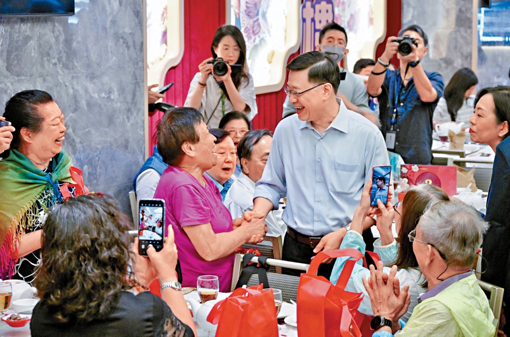 李家超在一間酒樓與百名長者共享午宴，親切與長者握手問好。