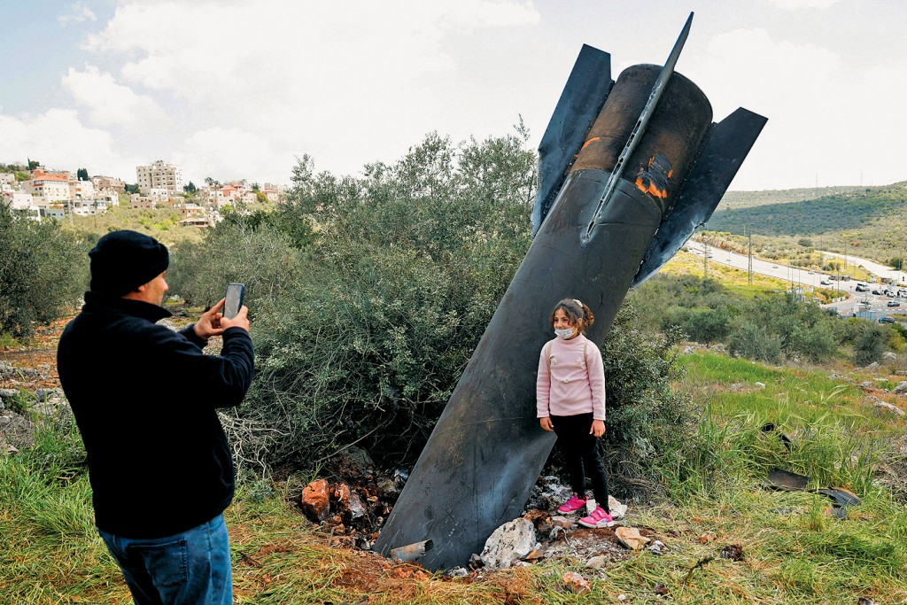 在約旦河西岸納布盧斯附近的村落，有女孩在導彈殘骸旁拍照。 