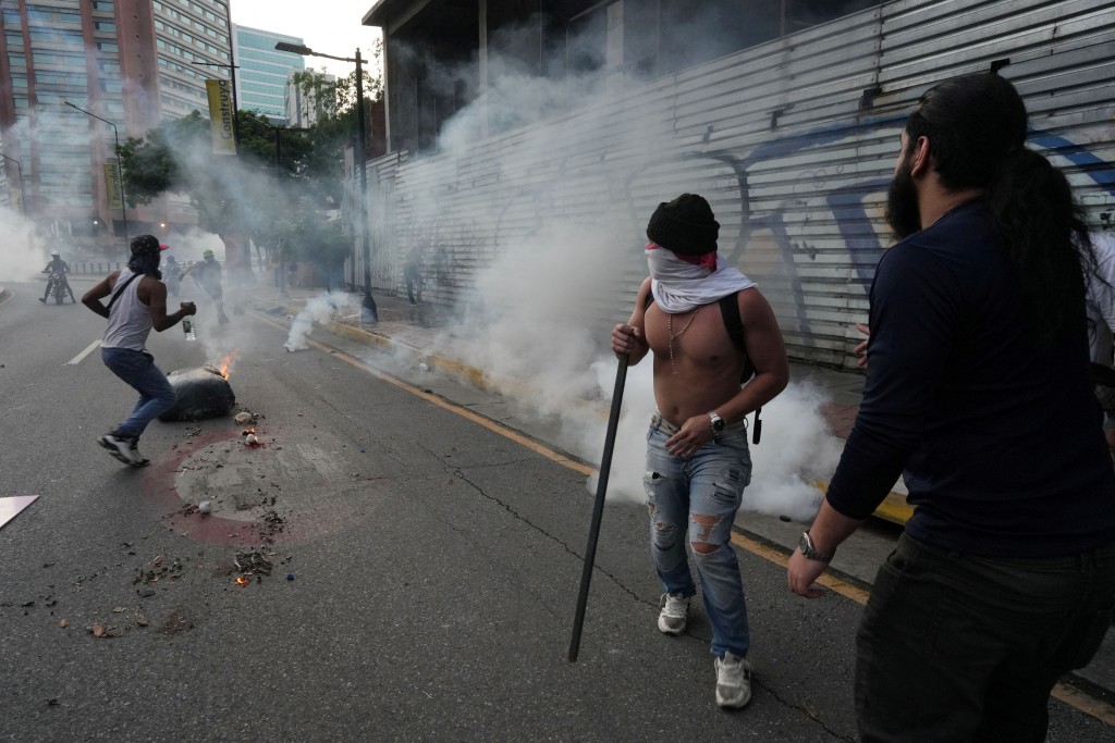 防暴警察发射催泪弹驱散示威者。路透社