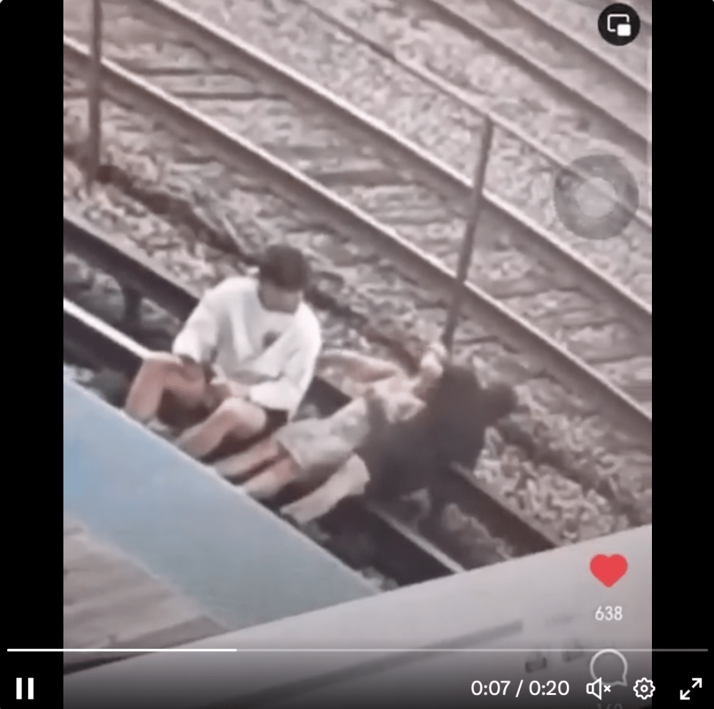 兩人雙雙癱卧在鐵軌之上，情勢危急。