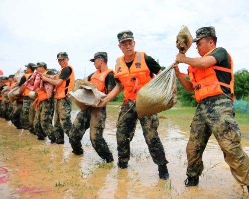 防洪堤決堤,武警運送沙包加固堤壩。AP圖