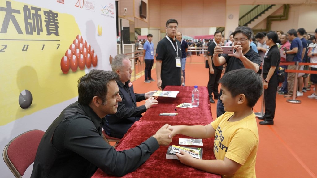17年香港舉辦桌球大師賽，奧蘇利雲(左)現身新伊館為小球迷簽名。 香港桌球總會圖片
