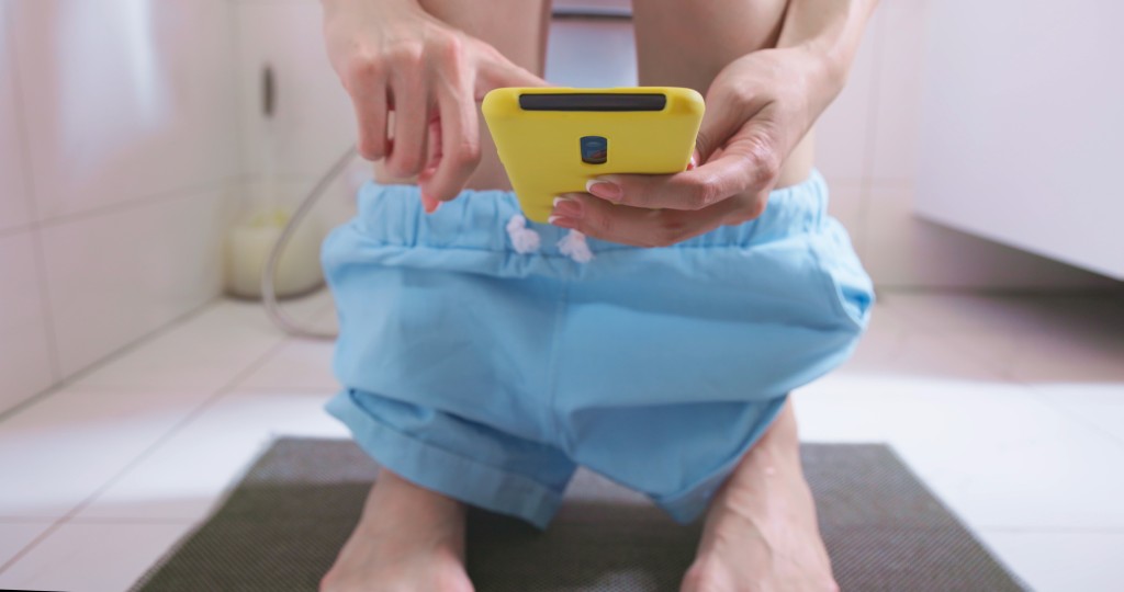 長期如廁玩手機影響健康。 iStock示意圖