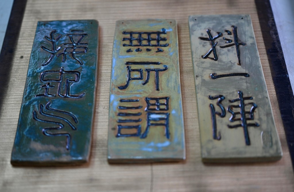 陶雕刻字展品用篆書、隸書、行書三種書體刻上廣東話潮語