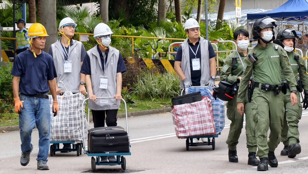 有義工、民安隊及警方人員協助居民由單位搬運物品。黃文威攝