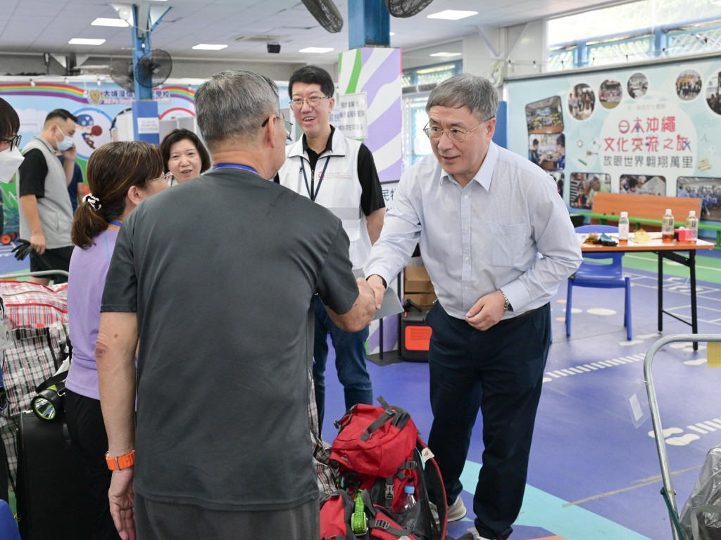 卓永興(右)與居民握手。 卓永興(右)與居民握手。