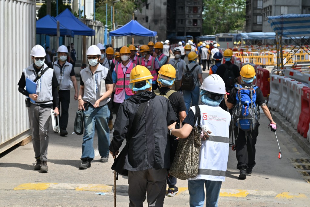 社工陪同上樓居民進入屋苑。政府新聞處圖片 社工陪同上樓居民進入屋苑。政府新聞處圖片