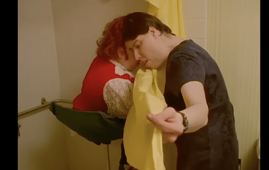 蘿莉（左）和喬治在1997年播出的《我們的生活》（Our Life）的紀錄片中，展示沖涼時會用浴簾保持私穩。Our Life紀錄片截圖