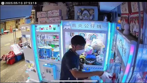 黑衫男向夾公仔機淋紅油。店主提供影片