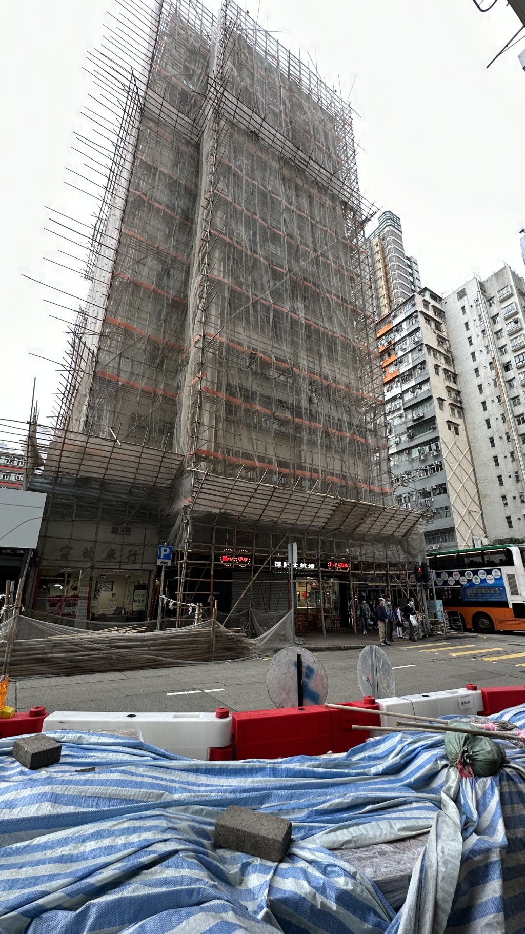 建新大厦正在搭棚进行强检维修工程，旁边有地盘正在打桩。(刘汉权摄)