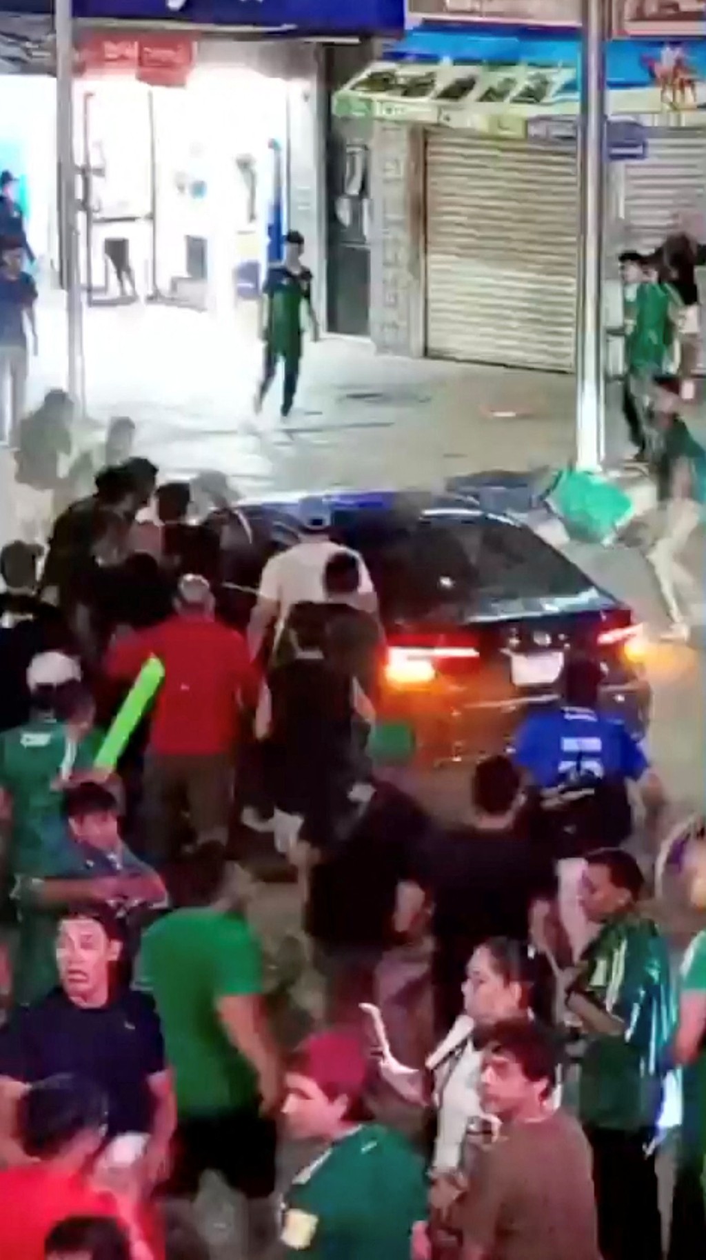 监视器拍到，一辆黑色私家车驶至集会现场，随即被情绪高涨的球迷包围。路透社