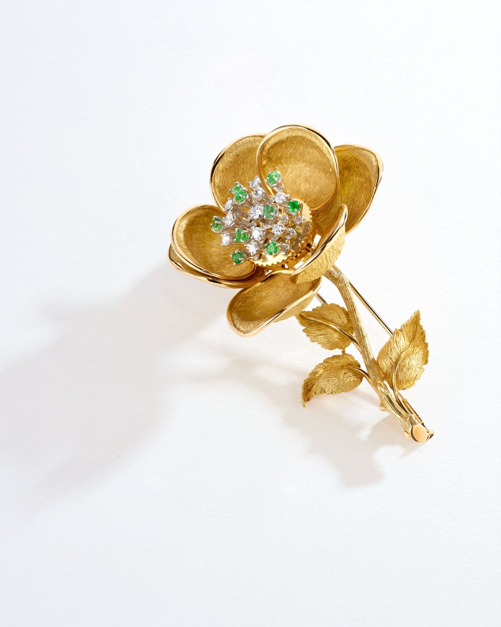 1966年的作品，黃金花形胸針鑲嵌鑽石及祖母綠。