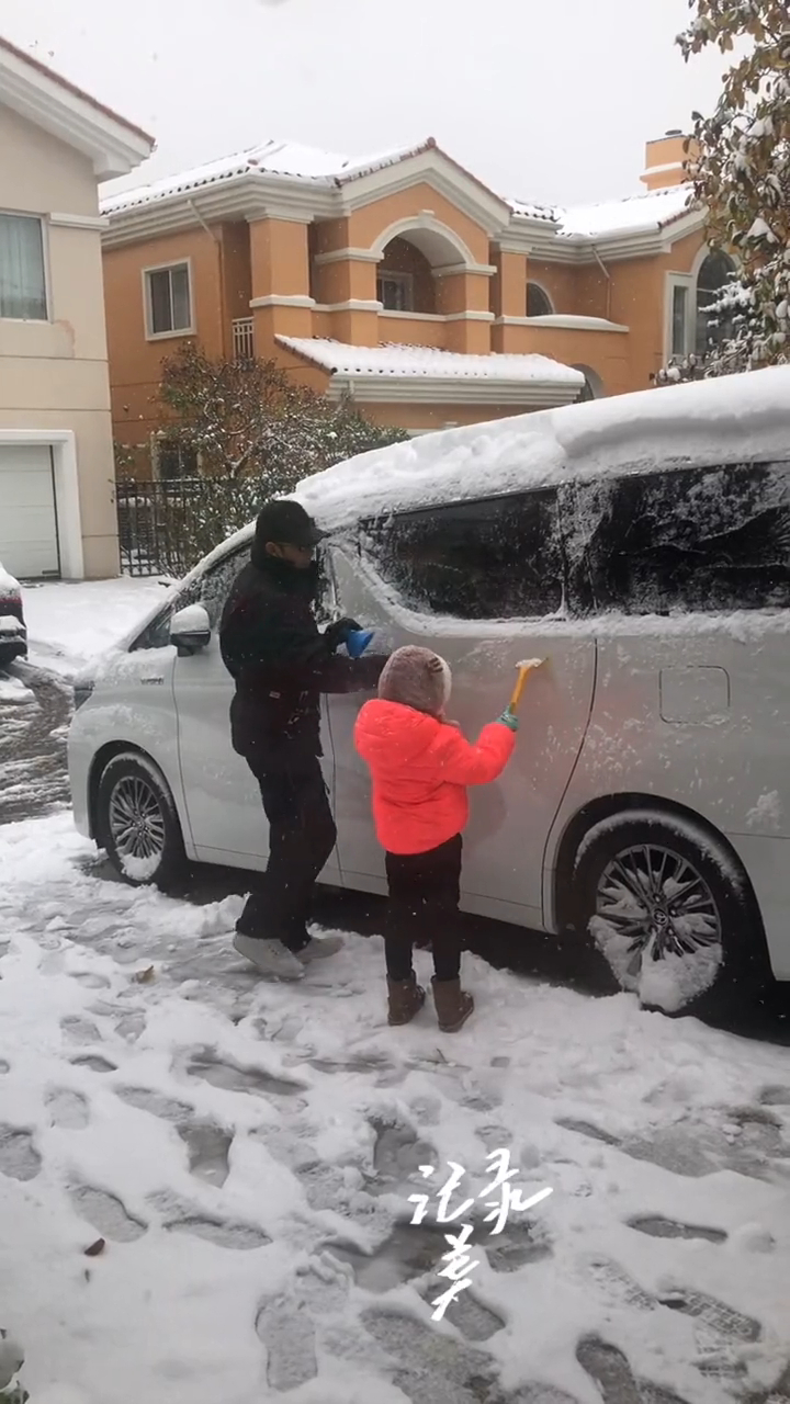 溫兆倫與囡囡一同為座駕剷雪。