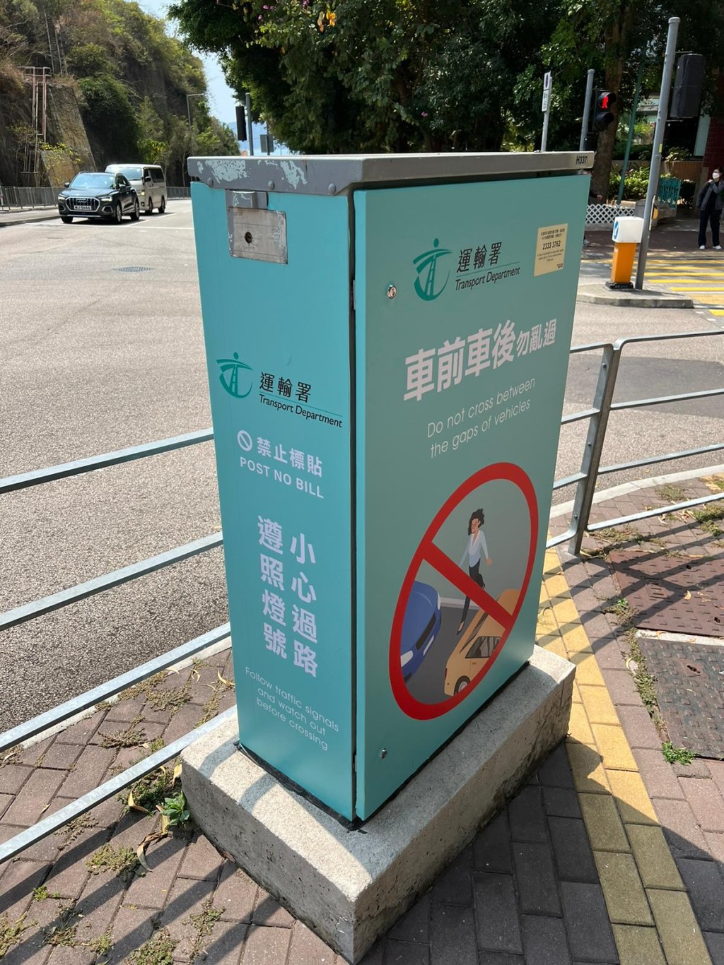 運輸署正陸續為交通燈控制器換上新衣，貼上多款帶有不同道路安全標語的全身宣傳畫貼，提醒道路使用者注意道路安全，以減低交通意外發生。圖示美化後的交通燈控制器，貼上小心過馬路的信息。（政府新聞處）