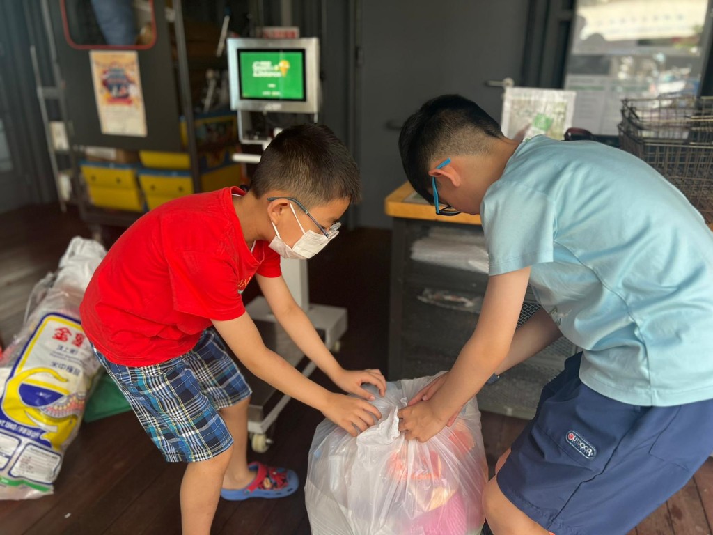 許正宇與家人到鄰近社區，將廢紙、塑膠及玻璃樽送到「綠在區區」回收站。財經事務及庫務局FB圖片