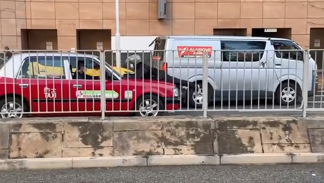鐵騎士趴在的士車頭，阻止的士司機開車。網上片段截圖
