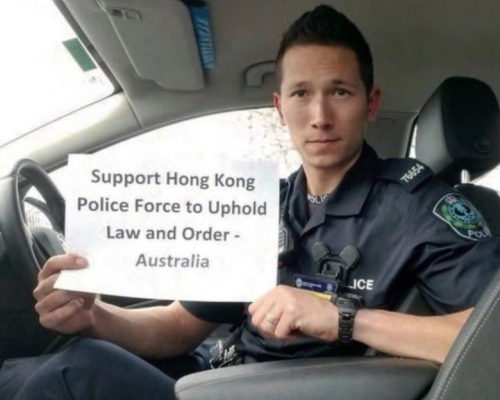 身穿制服的澳洲警員在車內展示撐港警標語。