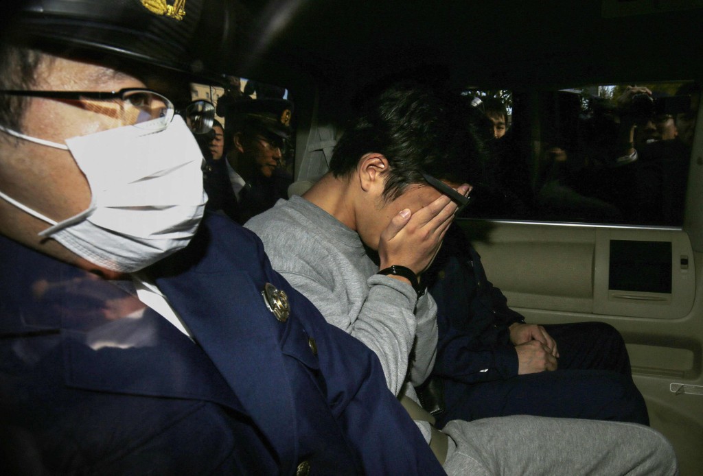 2017年11月,白石隆浩(圖中)從東京警察局被送往檢察院時,用手摀住臉。法新社