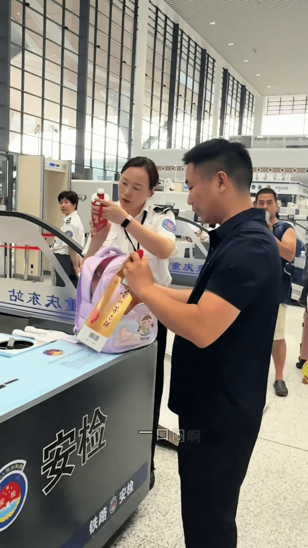 安檢正檢查男乘客的茅台。