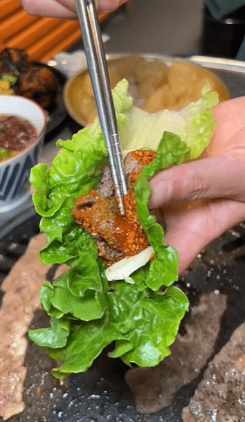 不少人食“韩烧”时，都喜欢以新鲜生菜包裹烤肉同吃。 抖音