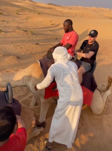拿比基达(红衫)和占士米拿(黑衫)一同骑骆驼。网上图片