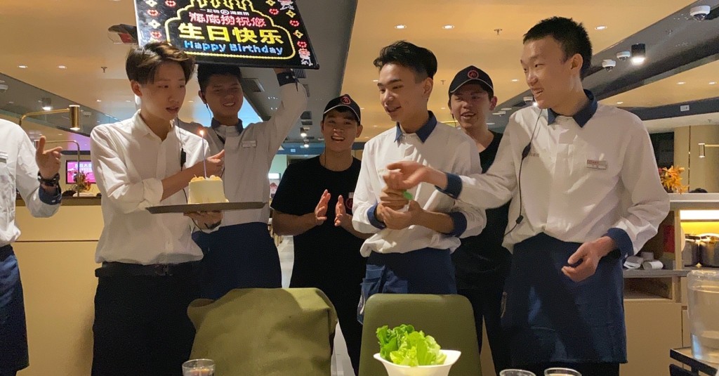 在海底撈過生日會有職員熱情地舉牌唱歌。網上圖片